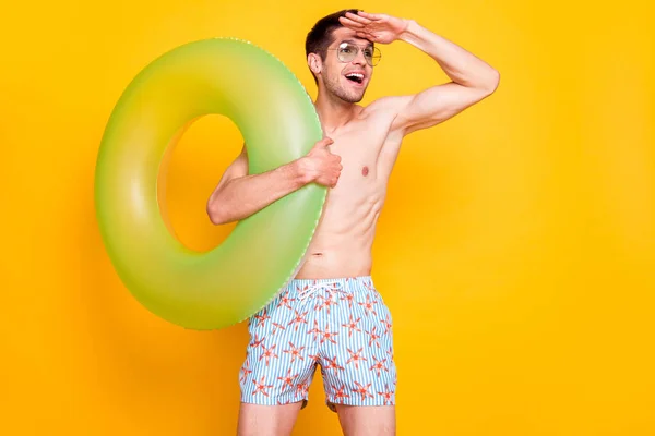 Foto de curioso hombre lindo torso desnudo gafas oscuras brazo frente mirando lejos espacio vacío sonriendo aislado color amarillo fondo — Foto de Stock