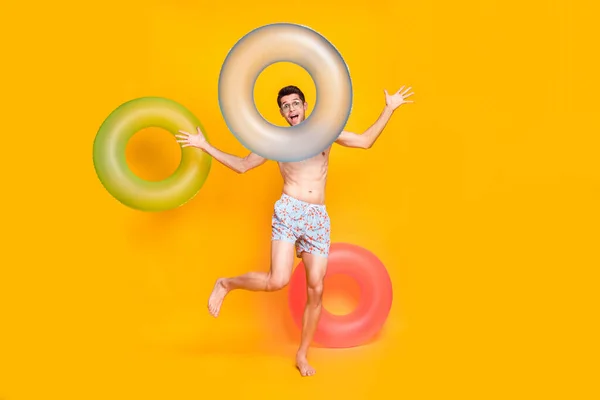 Full body photo of funny brunet millennial guy with buoy wear eyewear shorts isolated on yellow background — Photo