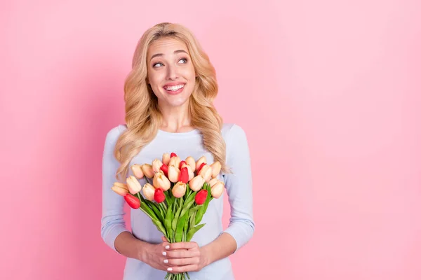 Foto de encantadora mujer joven soñadora feliz mirada espacio vacío mantenga las flores aisladas en el fondo de color rosa — Foto de Stock