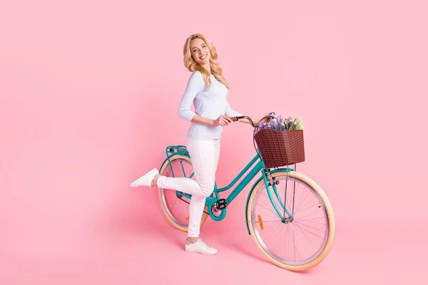 Pełny rozmiar zdjęcie uroczej młodej kobiety jeździć na rowerze wiosna nastrój uśmiech izolowany na różowy kolor tła — Zdjęcie stockowe