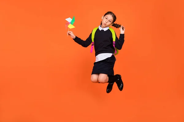 Ganzkörpergröße Ansicht von ziemlich lustig preteen Mädchen springen spielen Papier Fan Schmollmund Lippen isoliert über helle orange Farbe Hintergrund — Stockfoto