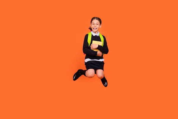 Full body photo of brunette small amazed shocked girl jump up hold hug book isolated on orange color background — Stock Photo, Image