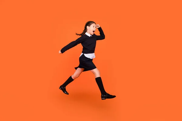 Vista completa del tamaño del cuerpo de la chica preadolescente alegre bastante motivada saltando corriendo aislado sobre fondo de color naranja brillante — Foto de Stock