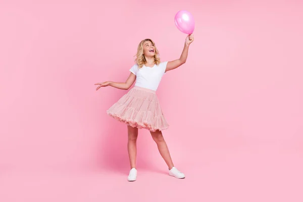 Foto de larga duración de la joven alegre sonrisa feliz aspecto positivo globo de aire decoración aislado sobre fondo de color rosa —  Fotos de Stock