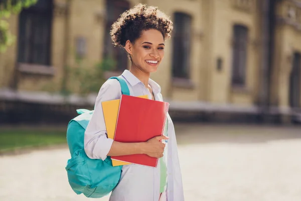 Perfil da foto lateral da jovem mulher africana alegre sorriso positivo feliz estudo educação mochila universitária ao ar livre — Fotografia de Stock