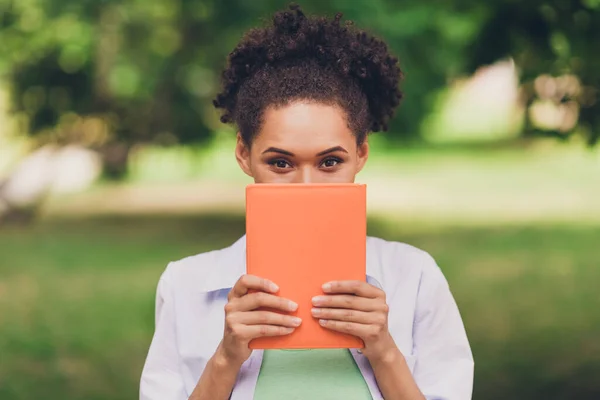 Foto di giovane felice donna afro americano attraente tenere le mani coprire il viso di buon umore all'aperto parco — Foto Stock