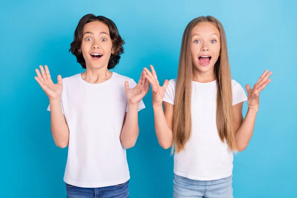 Foto retrato niños mirando asombrados gritando emocionado alegre aislado pastel color azul fondo —  Fotos de Stock