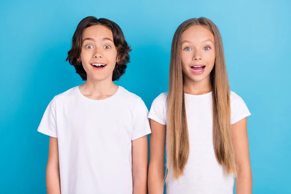 Fénykép két vicces őrült meglepett iskolások nyitott száj viselnek fehér póló elszigetelt kék háttér — Stock Fotó