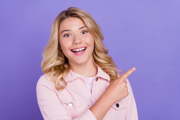 Foto de doce impressionado estudante usar roupa rosa apontando dedo vazio espaço sorrindo isolado cor violeta fundo — Fotografia de Stock