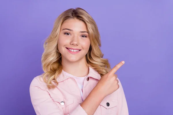 Foto von fröhlichen Teenager zeigen Finger leeren Raum Vorschlag isoliert auf pastellvioletten Hintergrund — Stockfoto