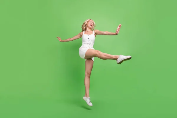Full size foto van funky grappige energieke sportieve meisje dansen stretching benen geïsoleerd op groene kleur achtergrond — Stockfoto