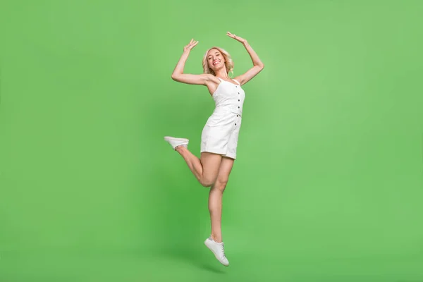 Pełnowymiarowe zdjęcie uśmiechniętej wspaniałej dziewczyny skacząc taniec energetyczny party club izolowane na zielonym tle — Zdjęcie stockowe