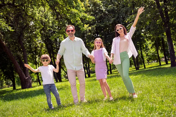 Foto de funky bonito preteen menino menina mãe pai vestido casual roupa subindo braços se divertindo andando sorrindo fora do parque da cidade — Fotografia de Stock