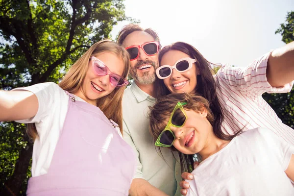 Foto de familia brillante divertida usar ropa casual gafas oscuras grabación sonriente vídeo al aire libre parque urbano de la ciudad — Foto de Stock