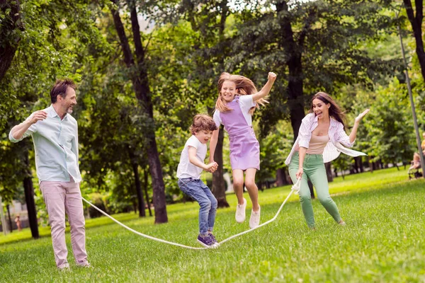 Photo of pretty funny family wear casual clothes smiling jumping skipping rope outdoors urban city park — Stock Photo, Image