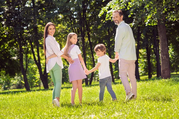 Longitud completa vista del tamaño del cuerpo de adopción atractiva familia alegre pasar tiempo en la hierba verde caminar aire fresco al aire libre — Foto de Stock