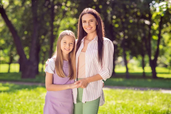 Photo of pretty charming mother daughter dressed casual outfit walking hugging smiling outside urban city street — Stock Photo, Image