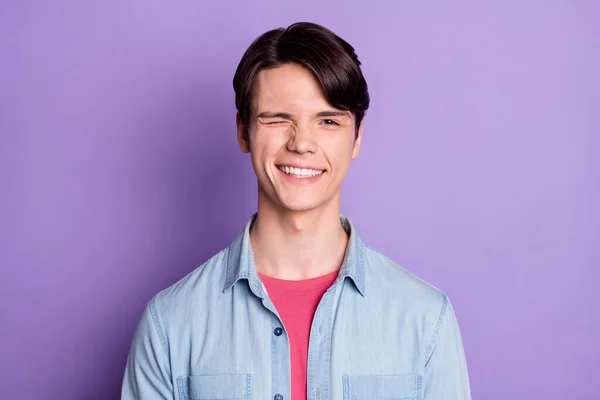 Foto de jovem alegre cara feliz sorriso positivo piscar olho funky isolado sobre cor violeta fundo — Fotografia de Stock