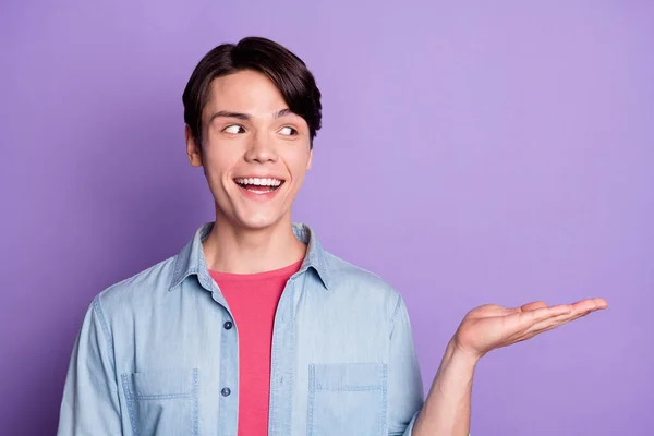 Foto van de jongeman gelukkig positieve glimlach houden product promo aanbieding advertenties kiezen geïsoleerd over violet kleur achtergrond — Stockfoto