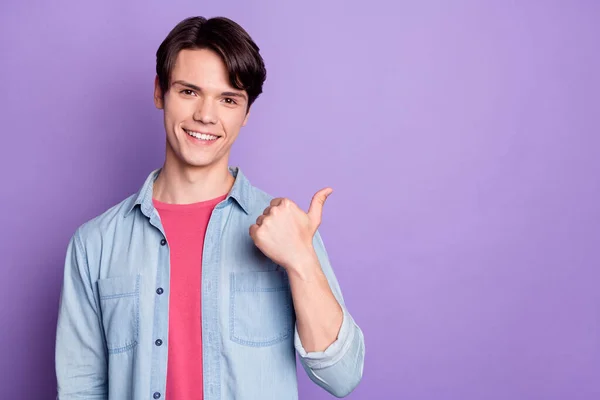 Foto des jungen Mannes glücklich positives Lächeln Punkt Daumen leer Raum direkte Entscheidung auswählen Anzeige isoliert über lila Farbe Hintergrund — Stockfoto