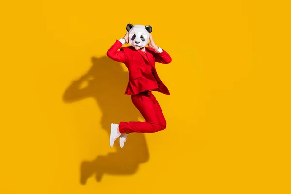 Foto von sportlichen verrückten Panda-Kerl springen genießen Flug tragen Maske roten Tux Schuhe isoliert auf gelbem Hintergrund — Stockfoto