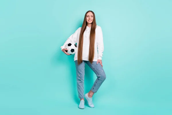 Ganzkörpergröße Ansicht der attraktiven fröhlichen Mädchen halten Ball posiert isoliert über helle türkisfarbene Farbe Hintergrund — Stockfoto