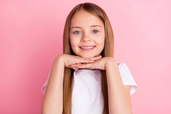 Foto van mooie blonde kleine meisje handen gezicht dragen witte t-shirt geïsoleerd op roze kleur achtergrond — Stockfoto