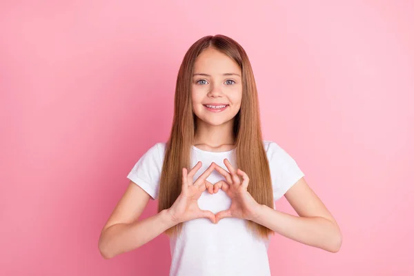 Foto van mooie blonde kleine meisje handen hart dragen witte t-shirt geïsoleerd op roze kleur achtergrond — Stockfoto
