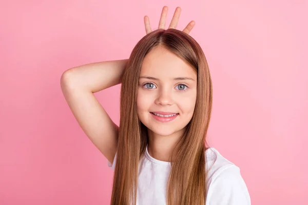 Foto van schattig blond klein meisje hand kroon dragen wit t-shirt geïsoleerd op roze kleur achtergrond — Stockfoto