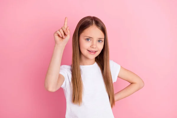 Foto van schattig blond klein meisje punt lege ruimte dragen wit t-shirt geïsoleerd op roze kleur achtergrond — Stockfoto