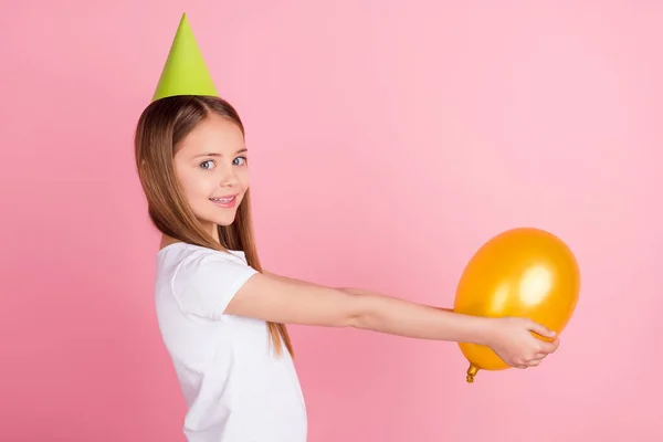 Profil fotografie legrační blond holčička držet balón nosit klobouk bílé tričko izolované na růžové barevné pozadí — Stock fotografie