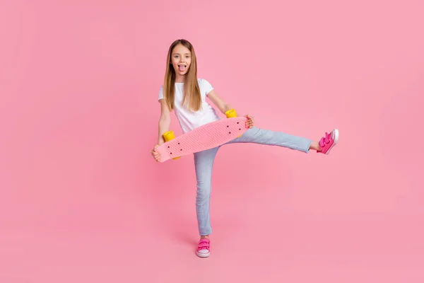 Полное фото тела милой блондинки язык из держать коньках носить белые джинсы футболки изолированы на розовом фоне цвета — стоковое фото