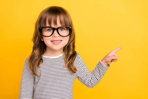 Φωτογραφία από έξυπνα μικρά ξανθά μαλλιά κορίτσι σημείο κενό χώρο φορούν γυαλιά ριγέ πουκάμισο απομονώνονται σε κίτρινο χρώμα backgound — Φωτογραφία Αρχείου