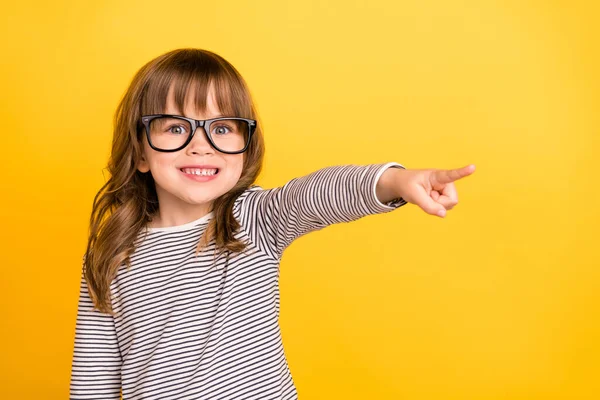 Φωτογραφία από χαριτωμένο λίγο ξανθά μαλλιά κορίτσι σημείο κενό χώρο φορούν γυαλιά ριγέ πουκάμισο απομονώνονται σε κίτρινο χρώμα backgound — Φωτογραφία Αρχείου