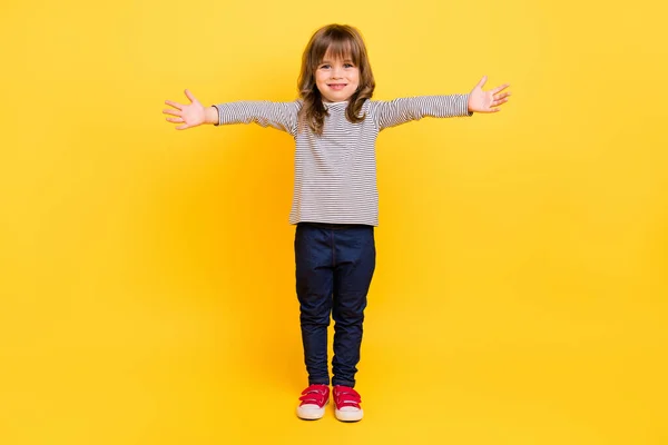 Full size foto di bella piccola ragazza capelli biondi tenere le mani indossare camicia jeans scarpe da ginnastica isolato su backgound giallo — Foto Stock