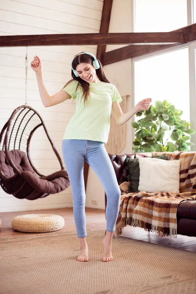 Вертикальна фотографія повного розміру солодкого тисячоліття леді танцю слухати музику одягати футболки джинси вдома поодинці — стокове фото