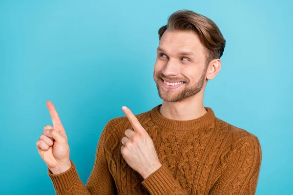 Foto de feliz encantador jovem apontar dedo vazio espaço informações isoladas no fundo cor azul pastel — Fotografia de Stock