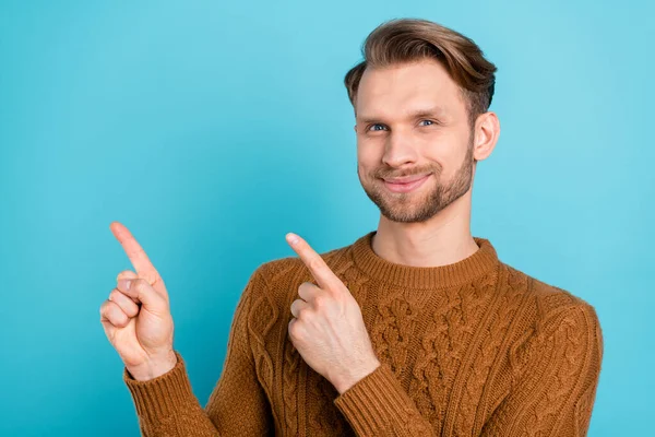 Φωτογραφία του γλυκού ελκυστική νεαρός ντυμένος πλεκτό πουλόβερ χαμογελώντας δείχνοντας τα δάχτυλα κενό χώρο απομονωμένο φόντο μπλε χρώμα — Φωτογραφία Αρχείου