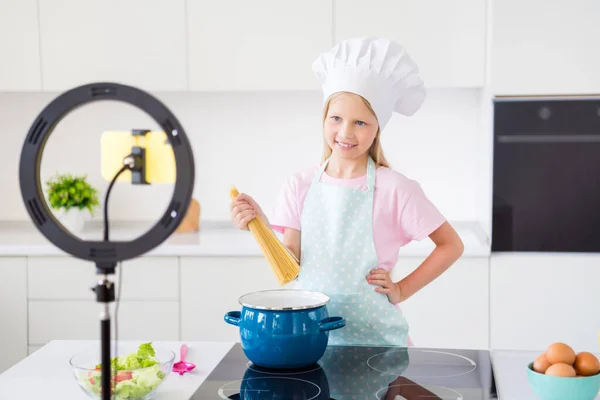 Foto di giovane bambina felice sorriso positivo cuoco spaghetti blogger ripresa video tutorial cucina al chiuso — Foto Stock