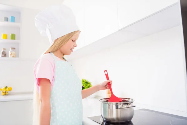 Foto di giovane felice felice ragazza piccola fanno zuppa tenere cucchiaio padella indossare cappello chef all'interno della casa cucina — Foto Stock