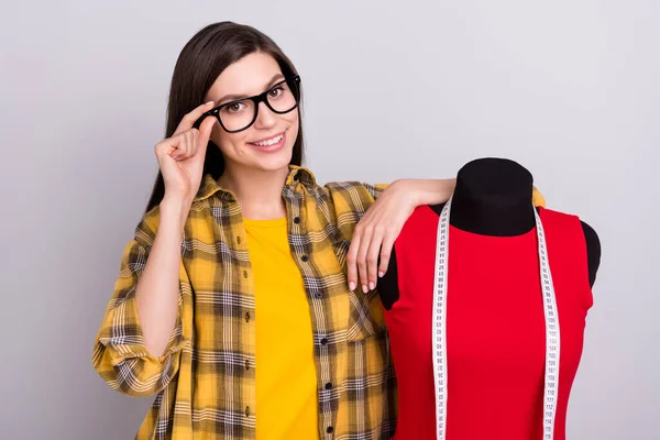 Foto der jungen Frau glücklich positives Lächeln Hand berühren Brille Schaufensterpuppe Stylist isoliert über graue Farbe Hintergrund — Stockfoto