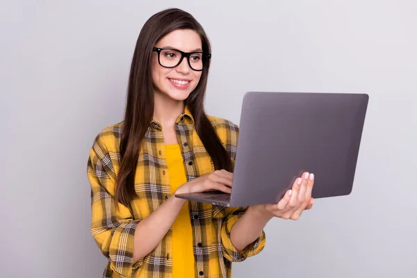 Foto de joven mujer de negocios feliz sonrisa positiva mirada leer navegar portátil aislado sobre fondo de color gris —  Fotos de Stock