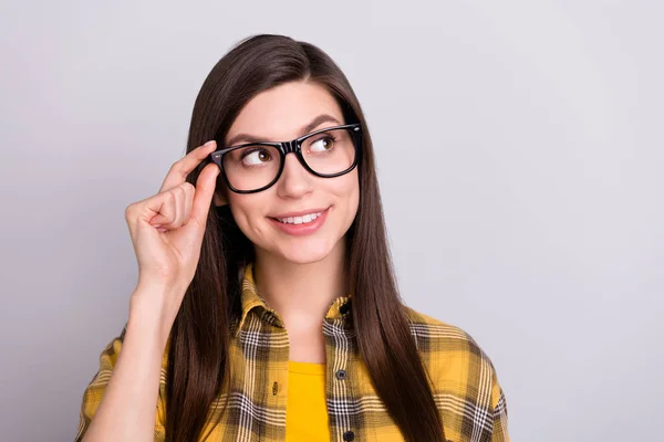 Foto de menina feliz sorriso positivo mão toque óculos olhar vazio espaço sonho isolado sobre fundo de cor cinza — Fotografia de Stock