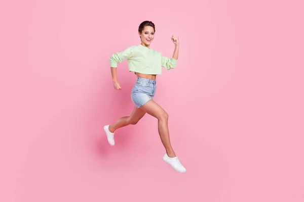 Foto de larga duración de alegre feliz mujer joven saltar corredor espacio vacío aislado en el fondo de color rosa —  Fotos de Stock