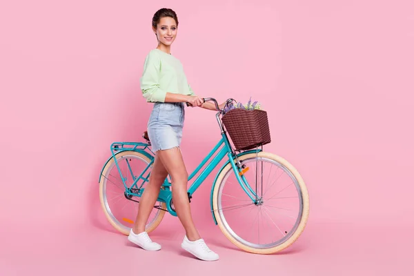Full size profil boczne zdjęcie młodej dziewczyny szczęśliwy pozytywny uśmiech iść pieszo rowerzysta rower izolowany na pastelowym tle kolor — Zdjęcie stockowe