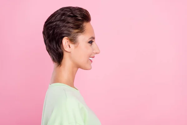 Profil sida foto av charmiga unga glad kvinna ser tomt utrymme leende isolerad på rosa färg bakgrund — Stockfoto