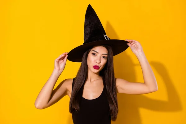 Korkunç cadı kadın dokunmatik şapka fotoğraf sarı arka planda izole siyah elbise giyer — Stok fotoğraf