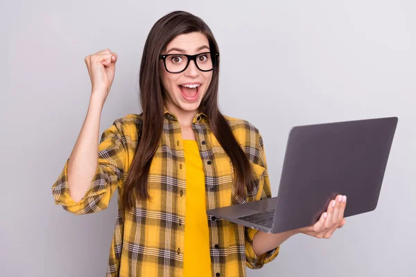 Fénykép a fiatal izgatott nő boldog pozitív mosoly örvendezzen győzelem siker tartsa laptop elszigetelt szürke színű háttér — Stock Fotó