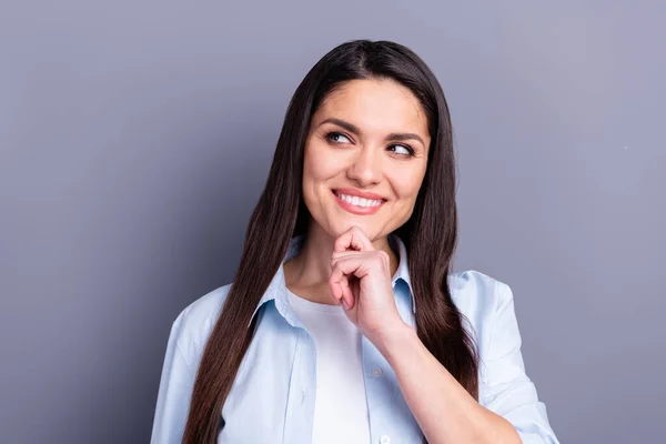 Foto de dulce linda señorita vestida azul camisa brazo barbilla sonriente buscando espacio vacío aislado gris color fondo —  Fotos de Stock