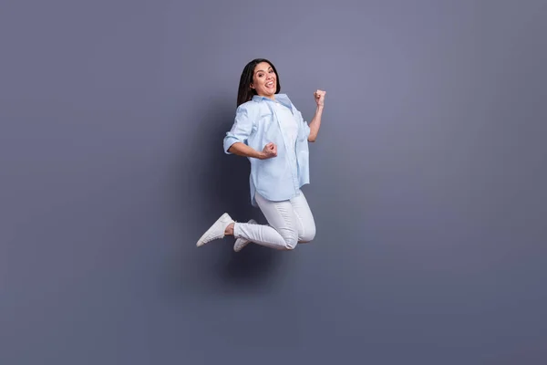 Pełna długość zdjęcie uroczej szczęśliwej dojrzałej kobiety nosić formalną koszulę podnoszące pięści skoków wysoki izolowany szary kolor tło — Zdjęcie stockowe